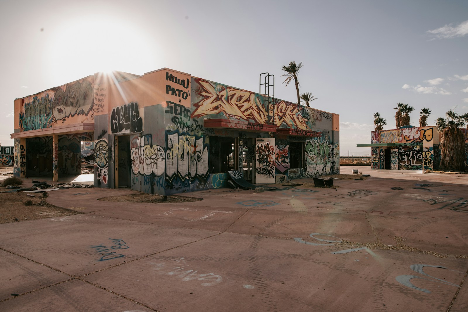 a building covered in graffiti and palm trees
